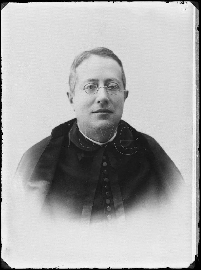 REPRODUCCION DE UNA FOTOGRAFIA DE UN SACERDOTE CON GAFAS