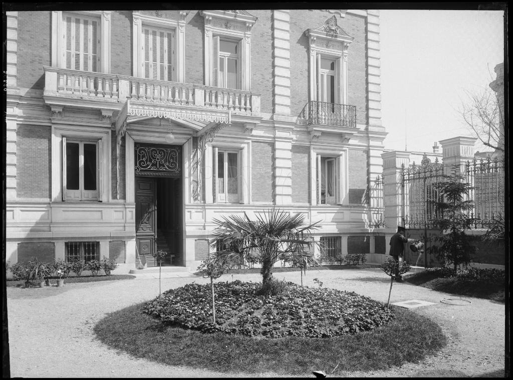 FOTOGRAFIA DEL JARDIN DE ENTRADA A UN EDIFICIO CON UN HOMBRE