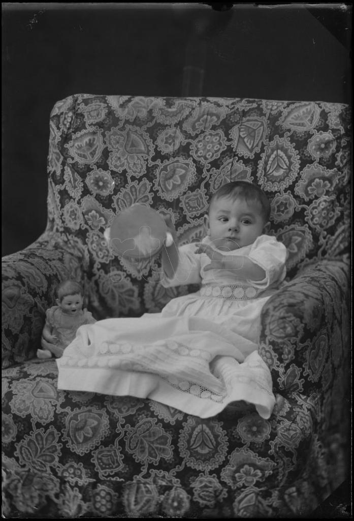 QUININ CON UNA PANDERETA, SENTADO EN UN SILLON