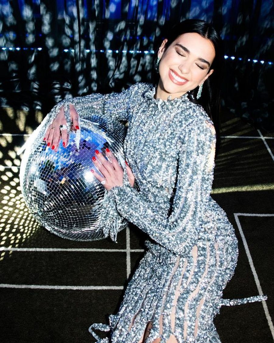 Dua Lipa escogió como vestido principal uno largo de brillantes blancos que imitan a los típicos cristales de una bola de discoteca