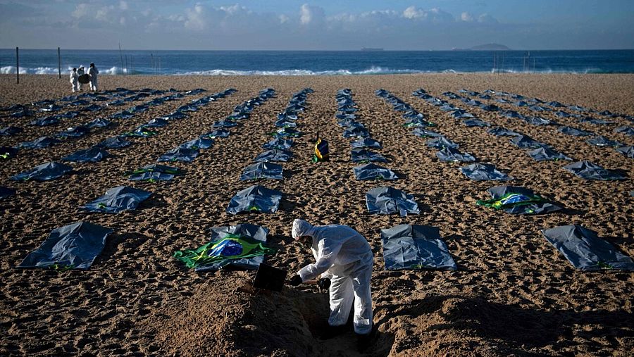 Activistas de la ONG pro-derechos humanos Rio de Paz cavan tumbas simbólicas en la playa de Copacabana, en Río de Janeiro, para protestar por la gestión de la pandemia por el gobierno de Jair Bolsonaro. CARL DE SOUZA / AFP