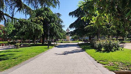 Vecinos de San Fernando de Henares se refugian a la sombra de los árboles en la plaza de Fernando VI, en el municipio de San Fernando de Henares.