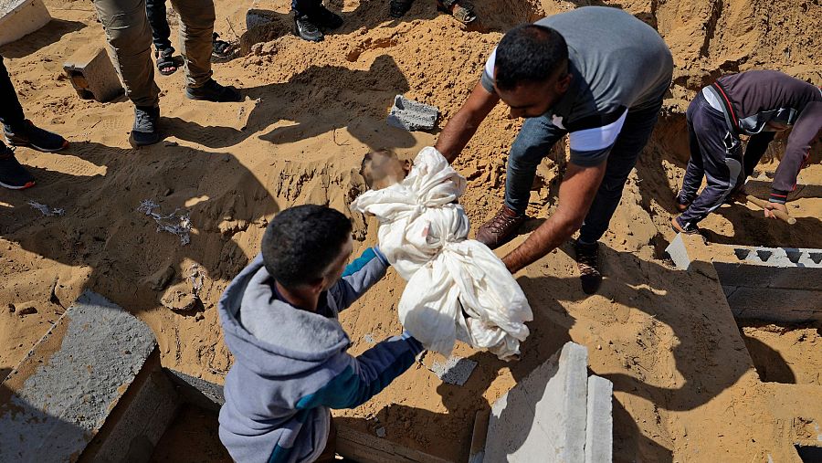 Hombres palestinos trasladando el cadáver de un niño pequeño que falleció en un ataque aéreo israelí