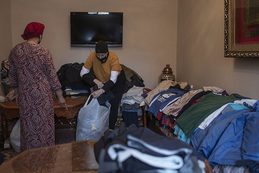Nabila y Aisha reparten ropa entre quienes han perdido sus prendas en la travesía hasta Ceuta.