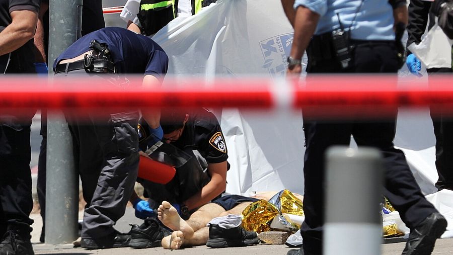 Fuerzas de seguridad israelíes junto al cuerpo del asaltante palestino que ha acuchillado a dos israelíes en Jerusalén antes de ser tiroteado. REUTERS/Ammar Awad