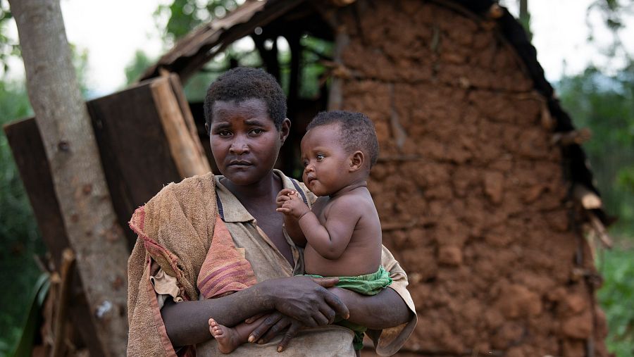Janvière Kangoro sostiene a Estela, uno de sus cuatro hijos, frente al refugio en el que ahora viven.