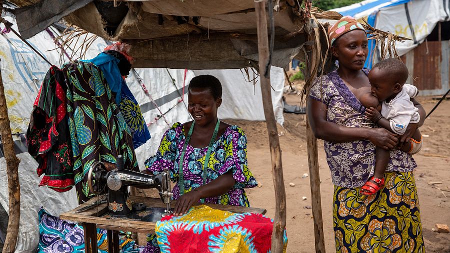 Jeannette Niyibigira, a la izquierda, regenta un pequeño negocio textil en el campo de Gatumba, que ha podido montar gracias a la ayuda humanitaria.