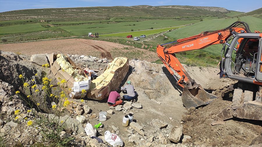 Paleontólogos junto al herrero Alberto Ros montando la estructura de hierro