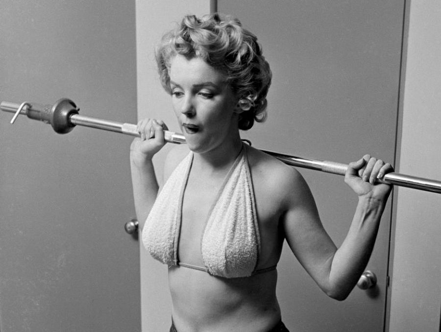 Marilyn entrenando con una barra y pesas para Pageant magazine en 1952.