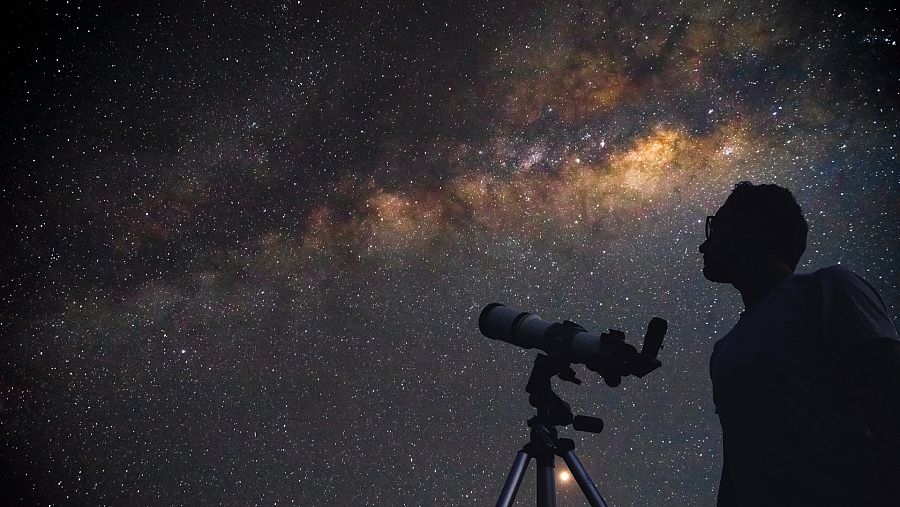 Imágen de una persona observando con un telescopio las estrellas
