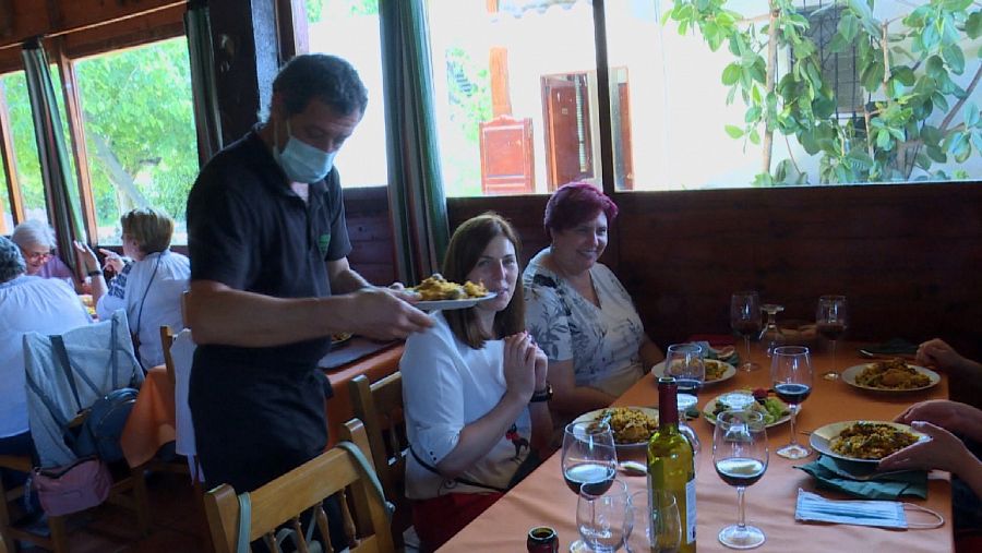 Un camarero sirviendo un plato de paella