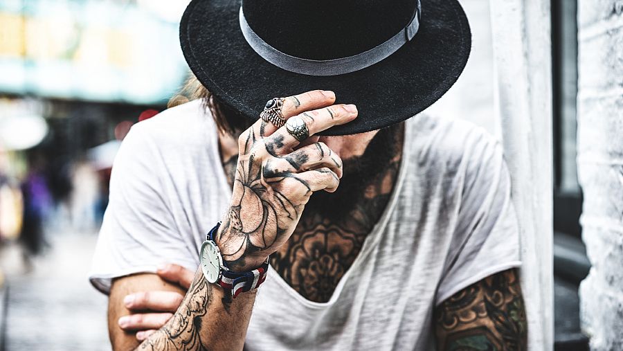 Imágen de un hombre tatuado en cara y brazos