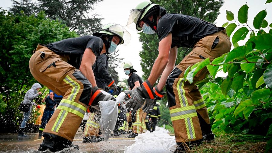 Los bomberos organizan bolsas de arena para controlar el aumento del río Düssel que ha dejado graves inundaciones en las calles de Grafenberg, Alemania, 14 de julio 2021. 