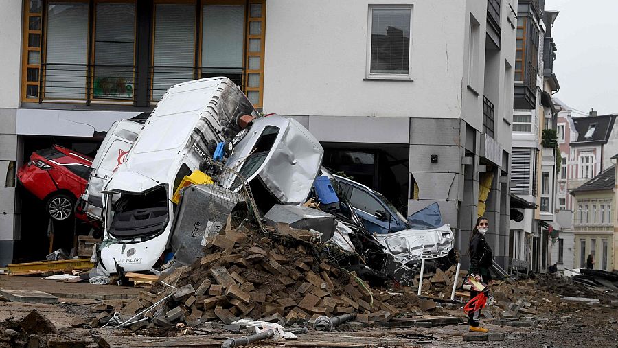 Una mujer ante una pila de coches en una calle de Bad Neuenahr-Ahrweiler
