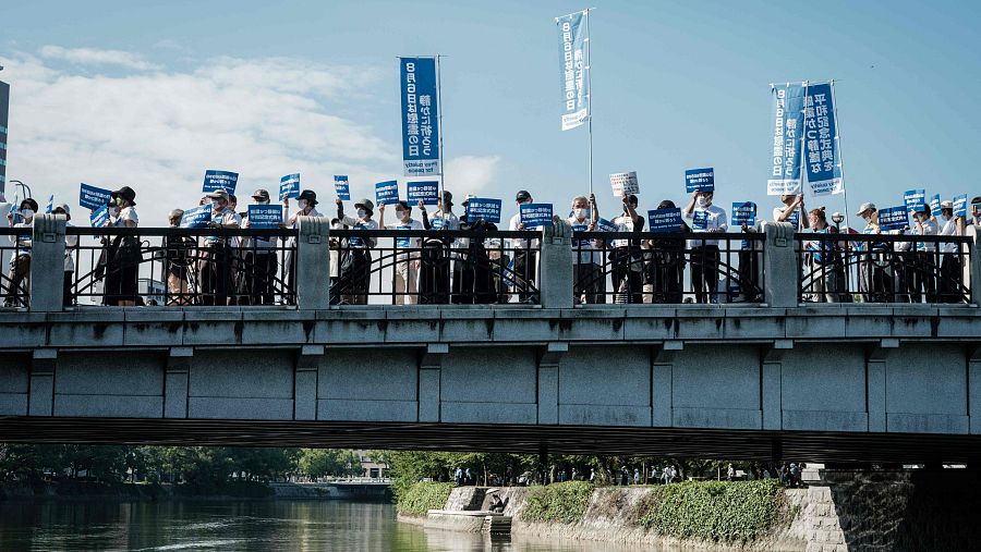 Manifestantes con pancartas que dicen 