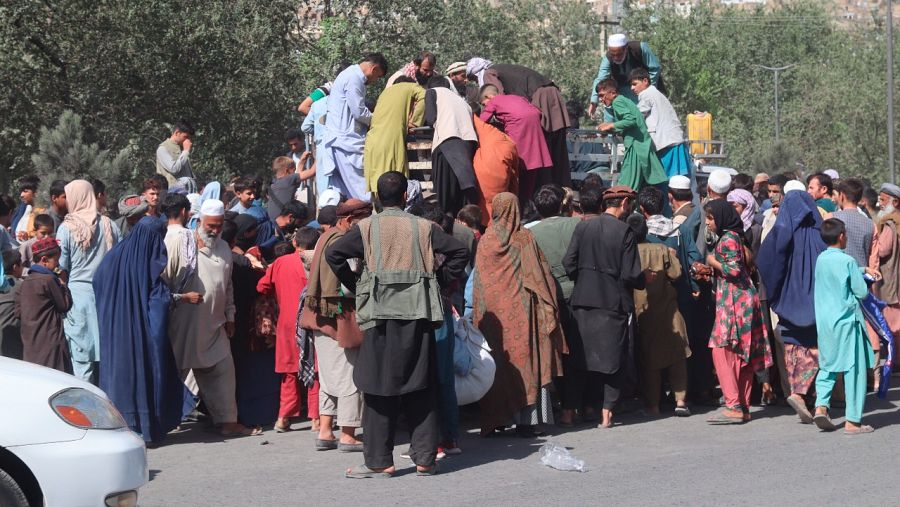 Los afganos desplazados de las provincias de Kunduz y Takhar debido a los combates entre las fuerzas talibanes y afganas se reúnen para recolectar alimentos, ya que viven en refugios temporales en un campamento en Kabul