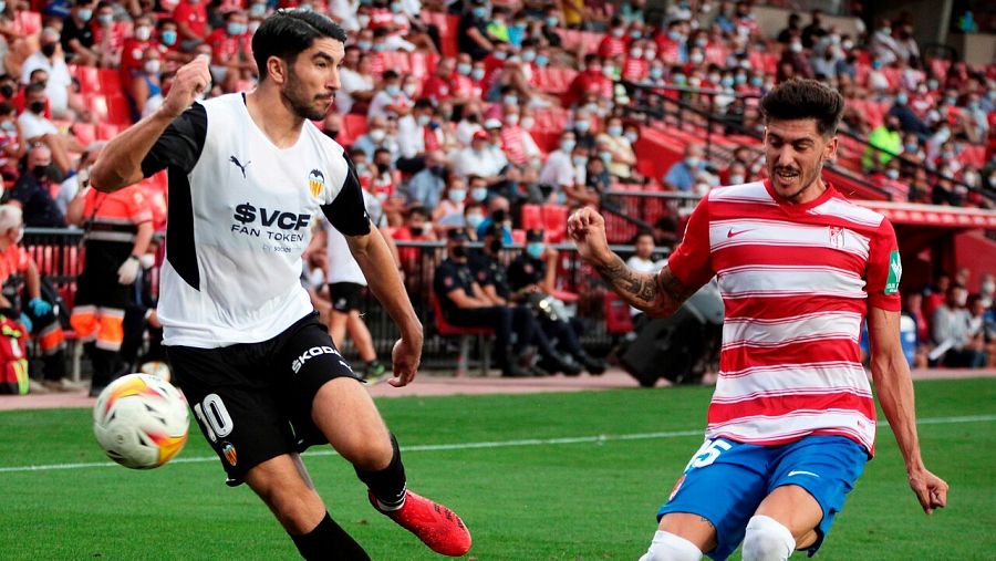El defensa del Granada CF Carlos Neva (d) presiona a Carlos Soler, del Valencia CF
