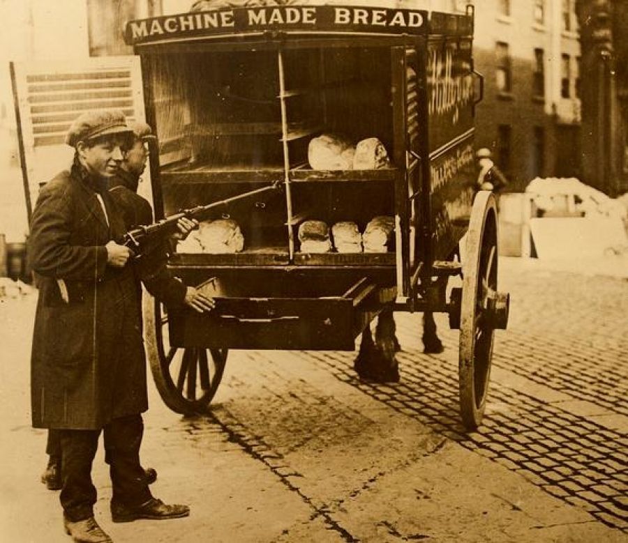 Muchacho vende pan en un puesto ambulante durante la época victoriana.