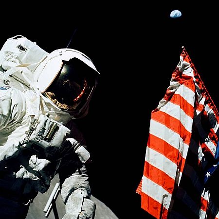 El científico y astronauta Harrison H. Schmitt junto a la bandera estadounidense