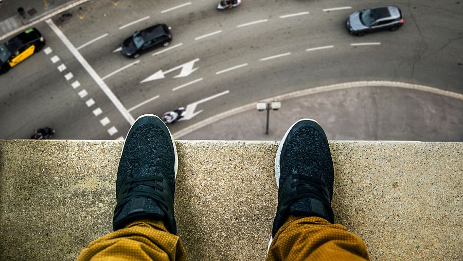 Imágen de los pies de una persona en lo alto de un edificio