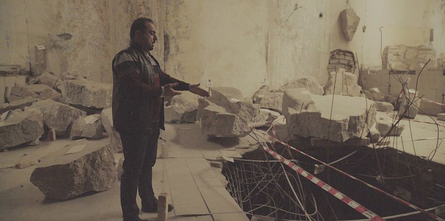 Un hombre señala en un museo lo que queda tras una incursión armada