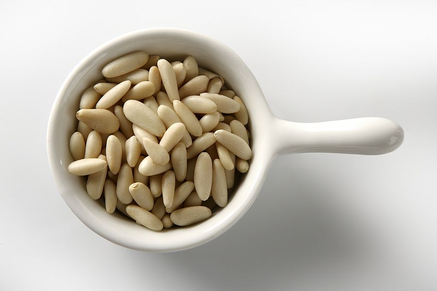 Abundant pine nuts in a close-up view, white background