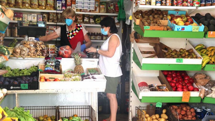 Pla tancat de l'Angelita Fibla, atenent una clienta a la seva fruiteria