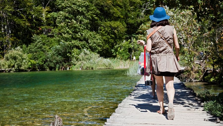 Turista caminando por la pasarela de madera en los Lagos Plitvice