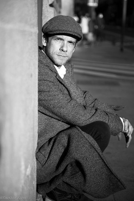 Fernando Ramallo sentado de lado en una escalera en una imagen en blanco y negro