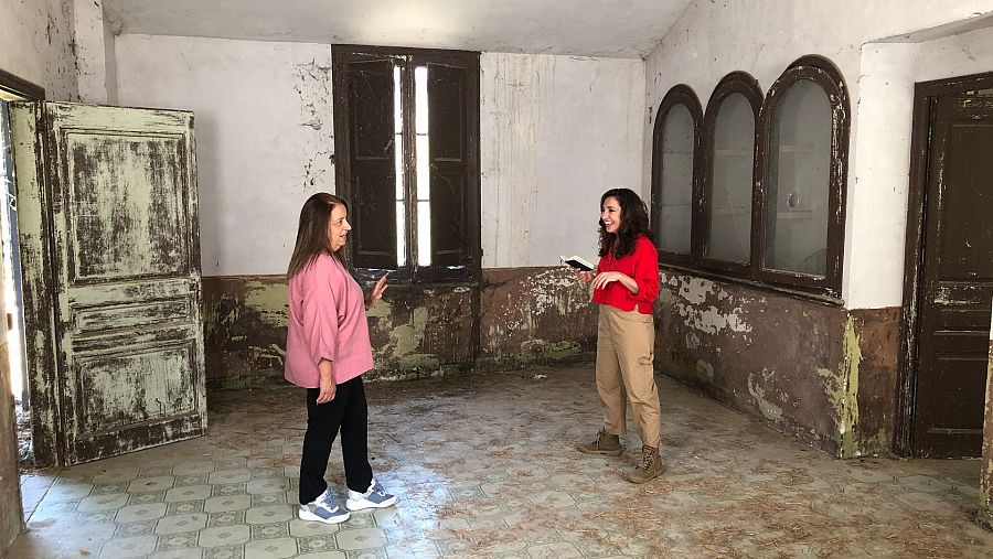 Anna Bertran amb una convidada a la sala d'una antiga fàbrica tèxtil