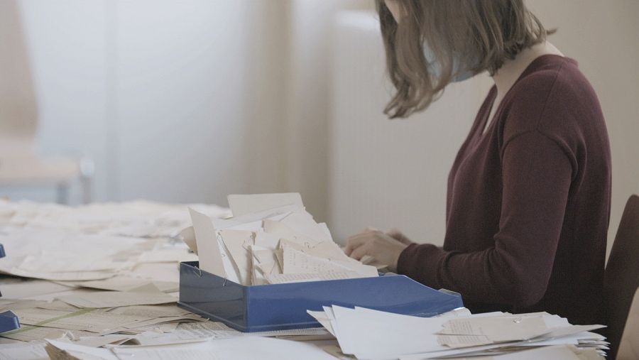 Mujer restaurando a mano expedientes de la Stasi