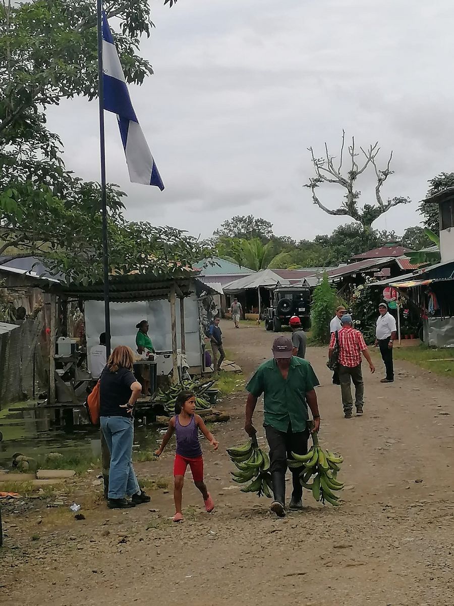 Paso fronterizo entre Nicaragua y Costa Rica con la bandera nicaragüense en una calle de tierra.