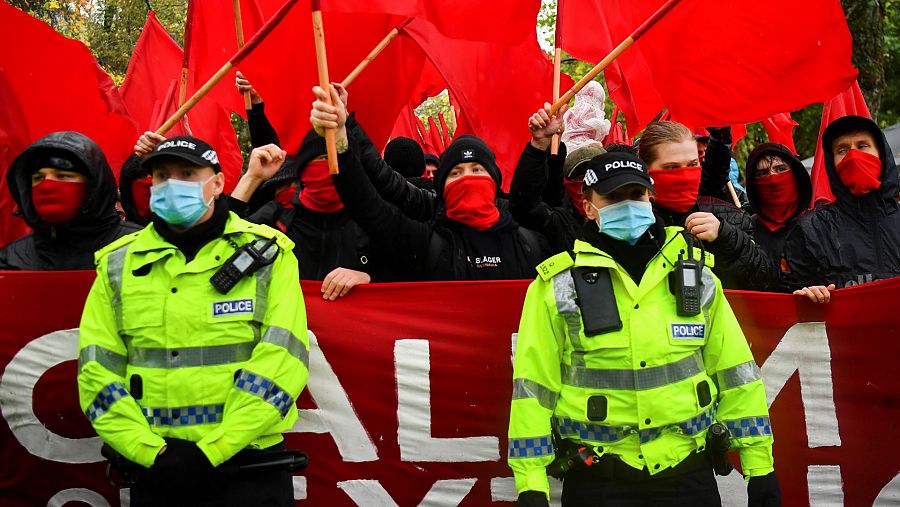 Varios agentes de policiía vigilan la marcha contra el cambio climático en las calles de Glasgow (Escocia).