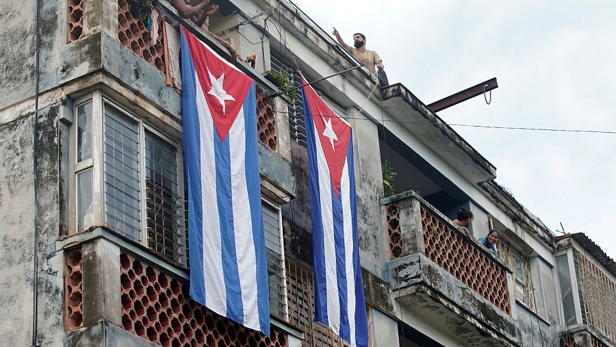 Un hombre cuelga una bandera cubana de un tejado para cubrir las ventanas de la casa de Yunior García, actor, dramaturgo y líder del grupo de Facebook llamado Archipiélago, en La Habana, Cuba, el 14 de noviembre de 2021. REUTERS / Alexandre Meneghini