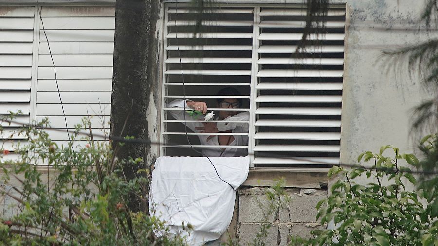 El actor, dramaturgo y líder del grupo de Facebook Archipiélago Yunior García, de 39 años, sostiene una flor detrás de una ventana de su casa en La Habana, Cuba, el 14 de noviembre de 2021