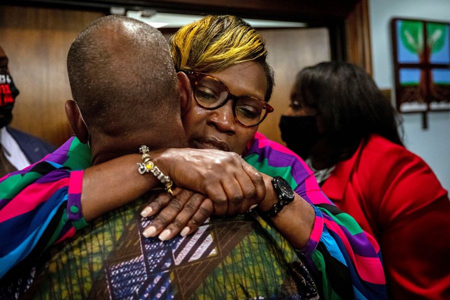 La madre de Ahmaud Arbery, Wanda Cooper-Jones, es abrazada por un compañero