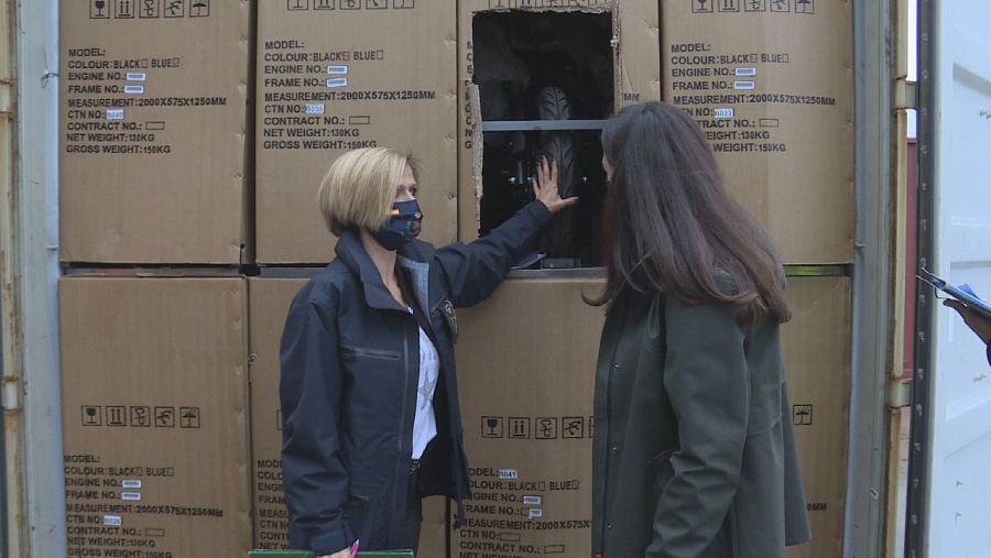 Una agente de aduanas inspecciona cajas en el puerto.
