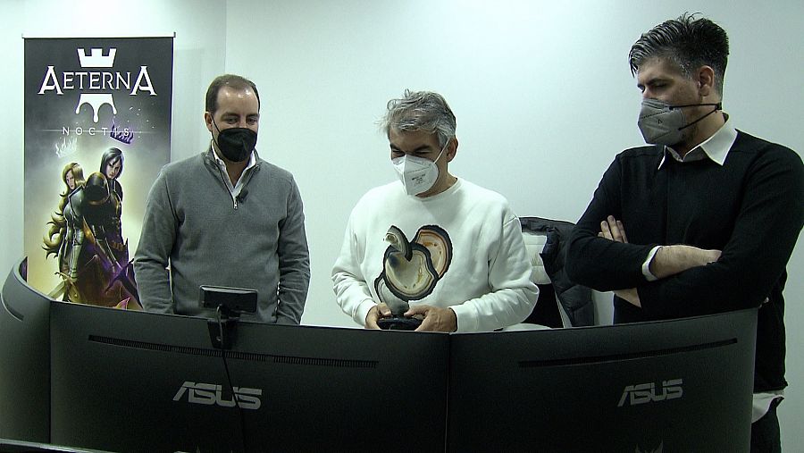 El director de Zoom Net, Manuel González, probando el videojuego junto a sus creadores.