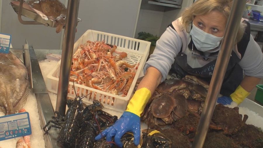 Una pescadera muestra el producto en su puesto