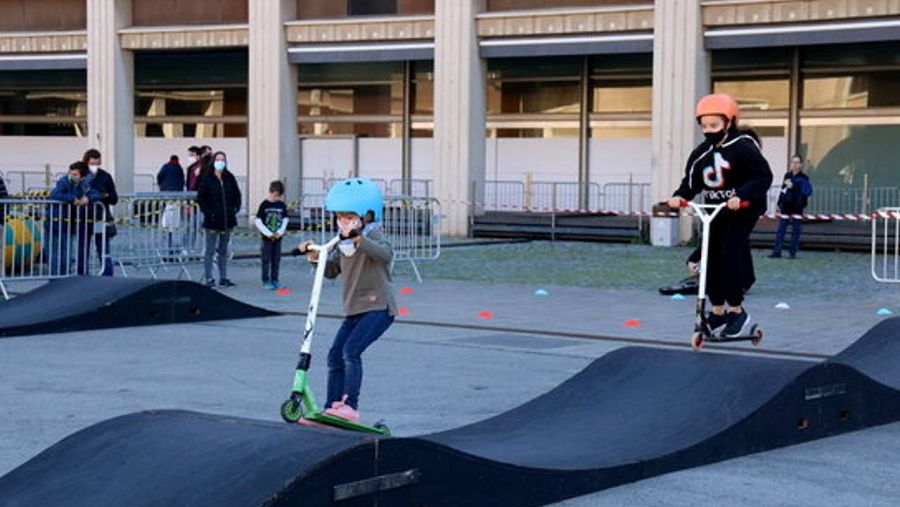 Dos infants anant en patinet per una pista d'obstacles a La Ciutat de la Diversió