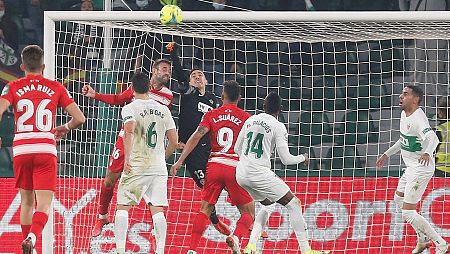 El portero del Elche Edgar Badía (c) despeja el balón ante el centrocampista del Granada Víctor Díaz (3i).