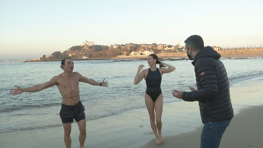 Dos personas salen del agua del mar en invierno.