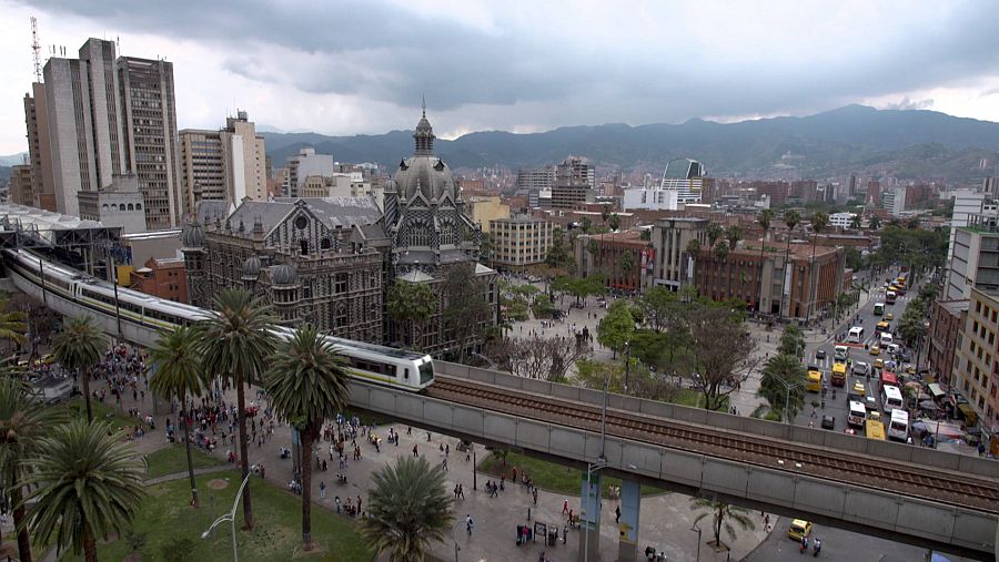 Paisatge d'una ciutat amb un tren elevat i darrere edificis
