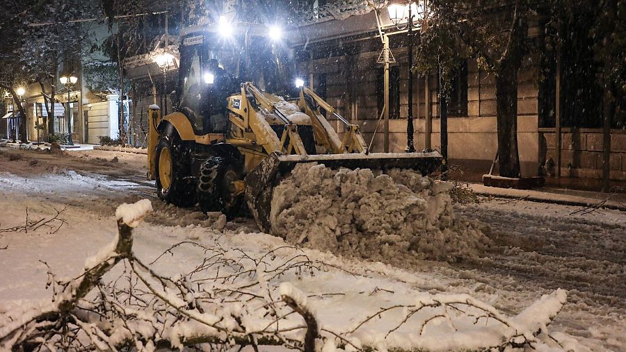 Una excavadora retira la nieve de una carretera del centro de Atenas (Grecia) en medio del temporal 'Elpis' o 'Elpida'