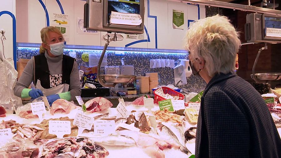 Una reportera de Comando Actualidad en un puesto de un mercado de abastos en Barcelona.