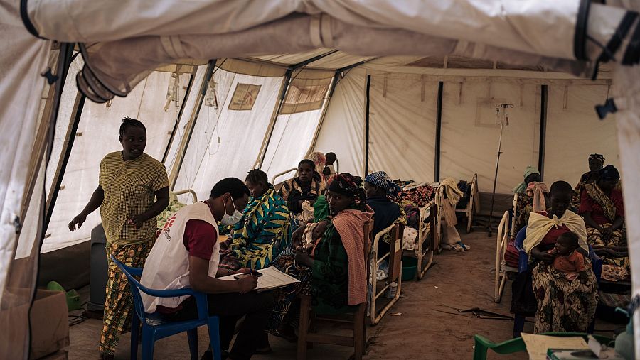 Varias mujeres con sus hijos están siendo atendidas en la carpa de pediatría del centro de salud del campamento de Rhoe