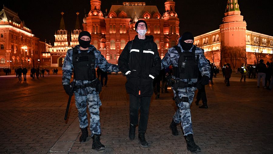 Dos policías rusos se llevan detenido a un manifestante por la invasión de Ucrania.