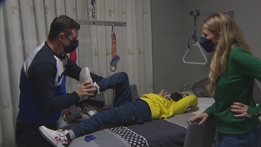 Ángel da un masaje a su hijo Nico, con parálisis cerebral.