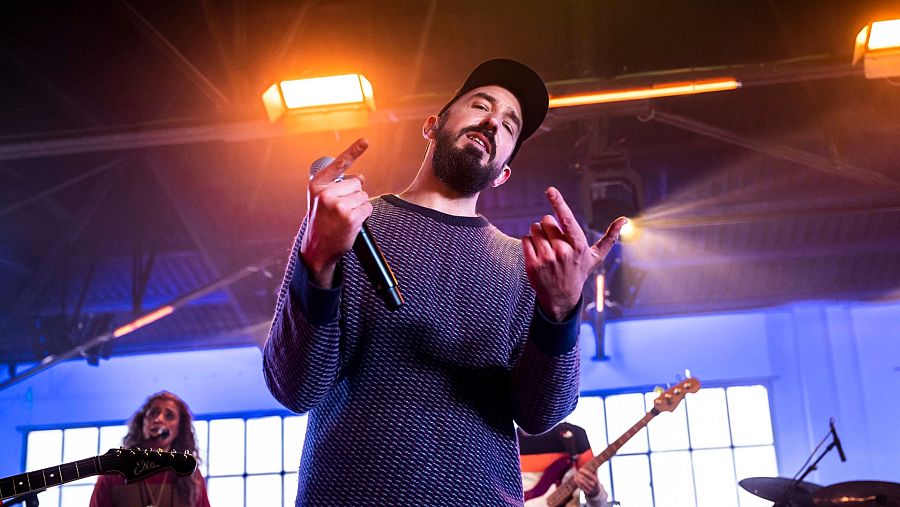 Rodrigo Laviña en primer pla amb una gorra i el micro a la mà
