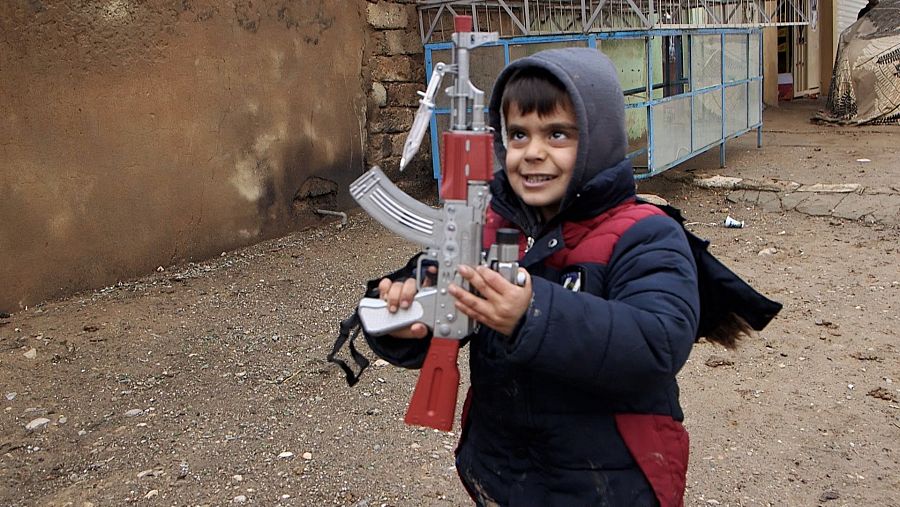 Imad mira de modo inquietante a su fusil de juguete